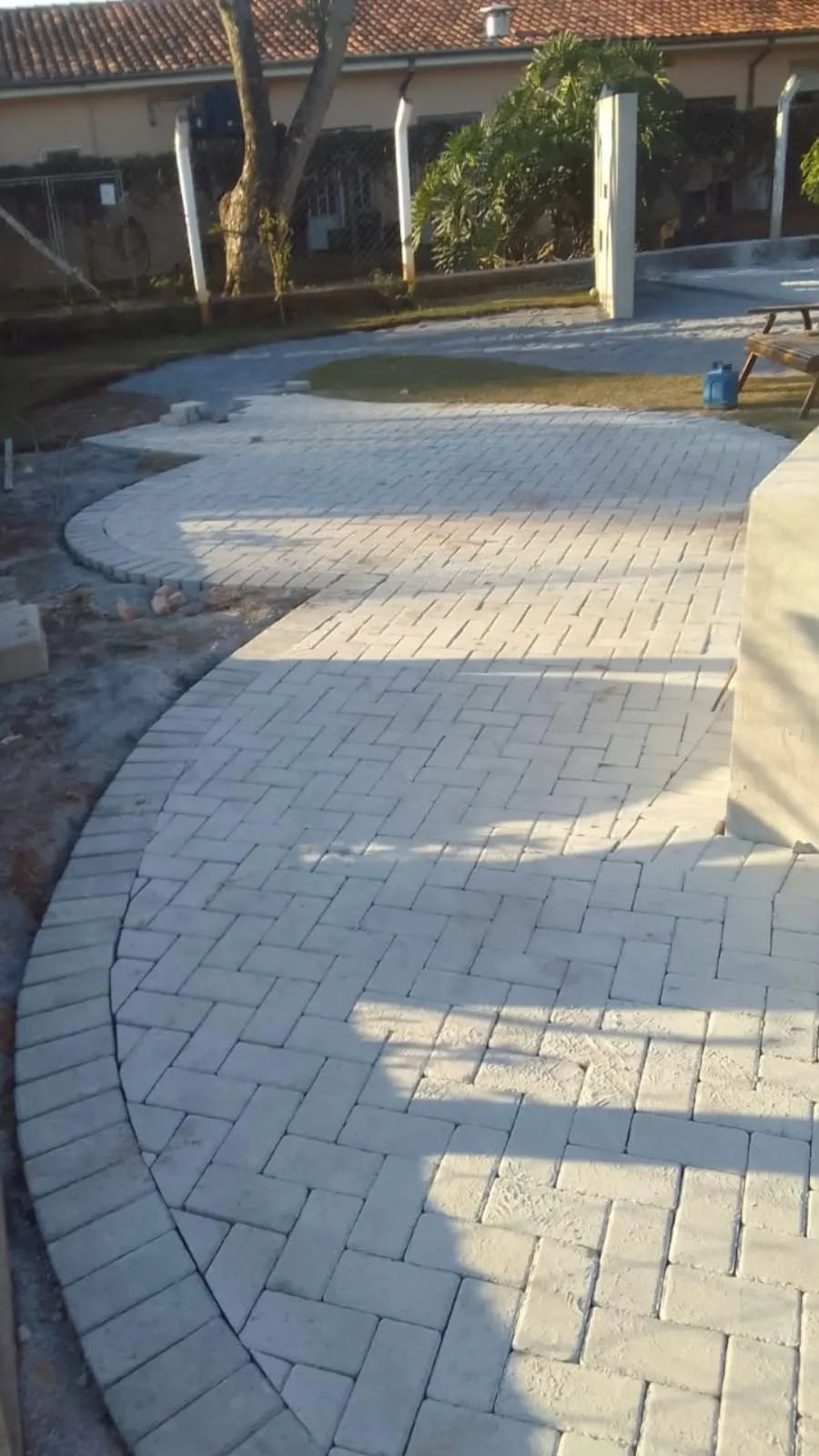Piso intertravado assentado em espinha de peixe, com borda curva